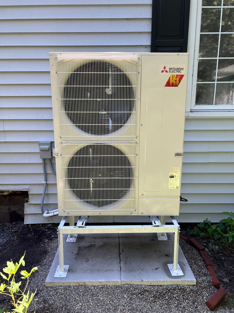 Mitsubishi Hyper-Heat outdoor unit on a snow stand.
